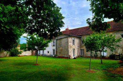 Deux réfrigérateurs professionnels vides dans une pièce carrelée avec une table en inox au premier plan.