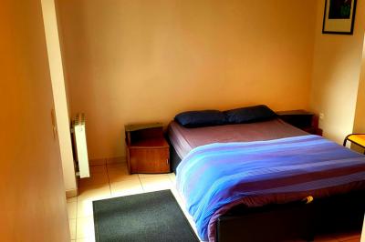 Deux réfrigérateurs professionnels vides dans une pièce carrelée avec une table en inox au premier plan.