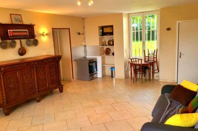 Deux réfrigérateurs professionnels vides dans une pièce carrelée avec une table en inox au premier plan.