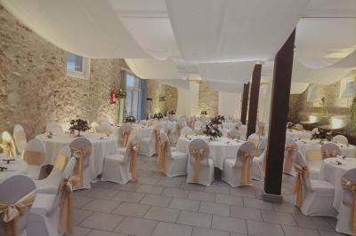 Deux réfrigérateurs professionnels vides dans une pièce carrelée avec une table en inox au premier plan.