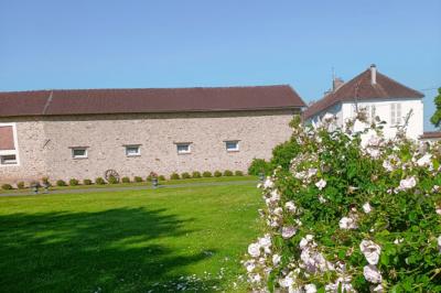 Deux réfrigérateurs professionnels vides dans une pièce carrelée avec une table en inox au premier plan.