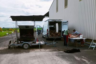 Deux réfrigérateurs professionnels vides dans une pièce carrelée avec une table en inox au premier plan.