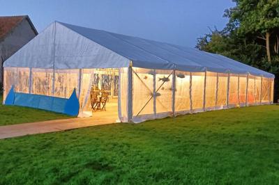 Deux réfrigérateurs professionnels vides dans une pièce carrelée avec une table en inox au premier plan.