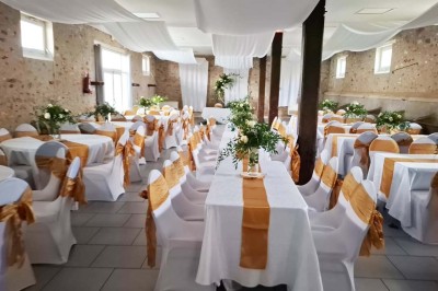 Deux réfrigérateurs professionnels vides dans une pièce carrelée avec une table en inox au premier plan.