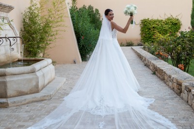 Miniature Location salle Coudoux (Bouches-du-Rhône) - Château Saint Hilaire #4 Un couple en tenue de mariage s'enlace dans un champ entouré d'oliviers sous une lumière douce.
