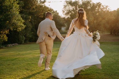 Miniature Location salle Coudoux (Bouches-du-Rhône) - Château Saint Hilaire #29 Un couple en tenue de mariage s'enlace dans un champ entouré d'oliviers sous une lumière douce.
