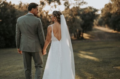 Miniature Location salle Coudoux (Bouches-du-Rhône) - Château Saint Hilaire #41 Un couple en tenue de mariage s'enlace dans un champ entouré d'oliviers sous une lumière douce.
