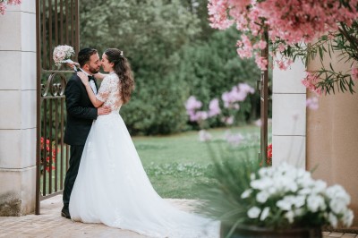 Miniature Location salle Coudoux (Bouches-du-Rhône) - Château Saint Hilaire #91 Un couple en tenue de mariage s'enlace dans un champ entouré d'oliviers sous une lumière douce.