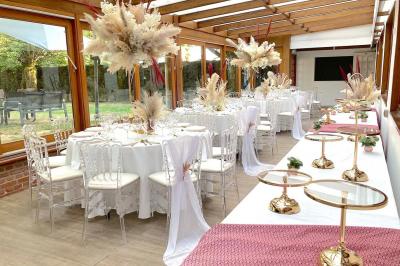 Table élégamment dressée avec vaisselle blanche et décorations florales, donnant sur une piste équestre en arrière-plan.