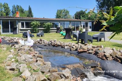 Table élégamment dressée avec vaisselle blanche et décorations florales, donnant sur une piste équestre en arrière-plan.