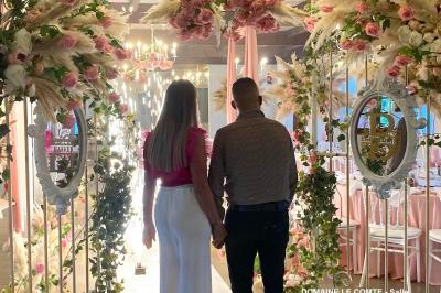 Table élégamment dressée avec vaisselle blanche et décorations florales, donnant sur une piste équestre en arrière-plan.