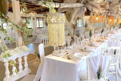 Table élégamment dressée avec vaisselle blanche et décorations florales, donnant sur une piste équestre en arrière-plan.