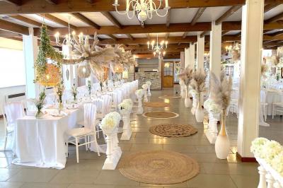 Table élégamment dressée avec vaisselle blanche et décorations florales, donnant sur une piste équestre en arrière-plan.