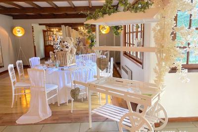 Table élégamment dressée avec vaisselle blanche et décorations florales, donnant sur une piste équestre en arrière-plan.