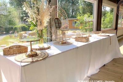 Table élégamment dressée avec vaisselle blanche et décorations florales, donnant sur une piste équestre en arrière-plan.