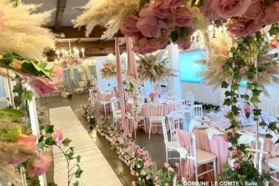 Table élégamment dressée avec vaisselle blanche et décorations florales, donnant sur une piste équestre en arrière-plan.