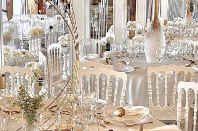 Table élégamment dressée avec vaisselle blanche et décorations florales, donnant sur une piste équestre en arrière-plan.