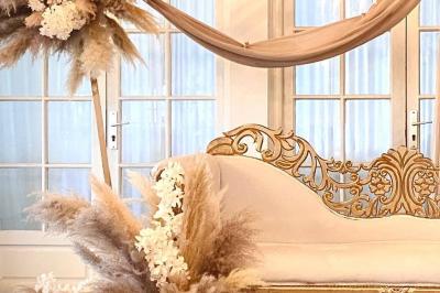 Table élégamment dressée avec vaisselle blanche et décorations florales, donnant sur une piste équestre en arrière-plan.