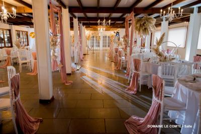 Table élégamment dressée avec vaisselle blanche et décorations florales, donnant sur une piste équestre en arrière-plan.