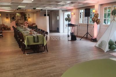 Table élégamment dressée avec vaisselle blanche et décorations florales, donnant sur une piste équestre en arrière-plan.