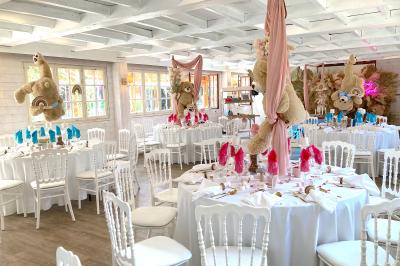 Table élégamment dressée avec vaisselle blanche et décorations florales, donnant sur une piste équestre en arrière-plan.