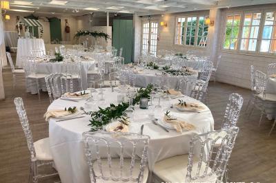 Table élégamment dressée avec vaisselle blanche et décorations florales, donnant sur une piste équestre en arrière-plan.