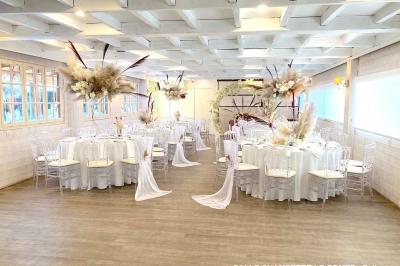 Table élégamment dressée avec vaisselle blanche et décorations florales, donnant sur une piste équestre en arrière-plan.