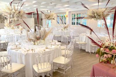 Table élégamment dressée avec vaisselle blanche et décorations florales, donnant sur une piste équestre en arrière-plan.