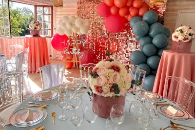 Table élégamment dressée avec vaisselle blanche et décorations florales, donnant sur une piste équestre en arrière-plan.