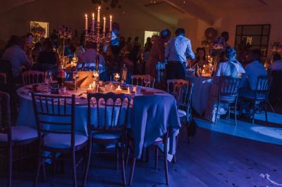 Salle de réunion lumineuse sous combles avec poutres apparentes, tables, chaises et écran de projection installé.