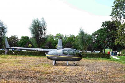 Salle de réunion lumineuse sous combles avec poutres apparentes, tables, chaises et écran de projection installé.