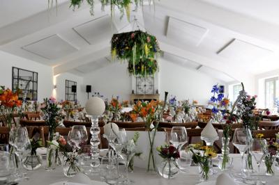 Salle de réunion lumineuse sous combles avec poutres apparentes, tables, chaises et écran de projection installé.