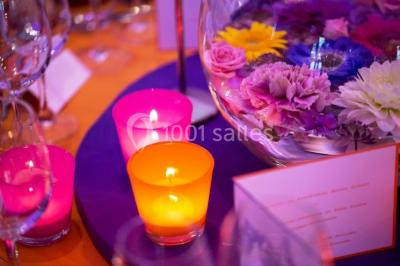 Vue d'un bâtiment en briques avec une tour, entouré d'arbres, d'une pelouse et d'un étang.