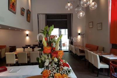Des personnes se servent à un buffet varié disposé sur des tables rondes dans une salle lumineuse.
