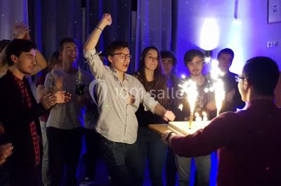 Des personnes se servent à un buffet varié disposé sur des tables rondes dans une salle lumineuse.