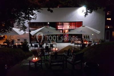 Des personnes se servent à un buffet varié disposé sur des tables rondes dans une salle lumineuse.