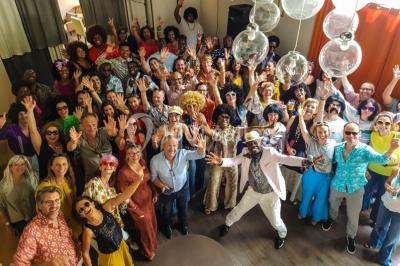 Des personnes se servent à un buffet varié disposé sur des tables rondes dans une salle lumineuse.
