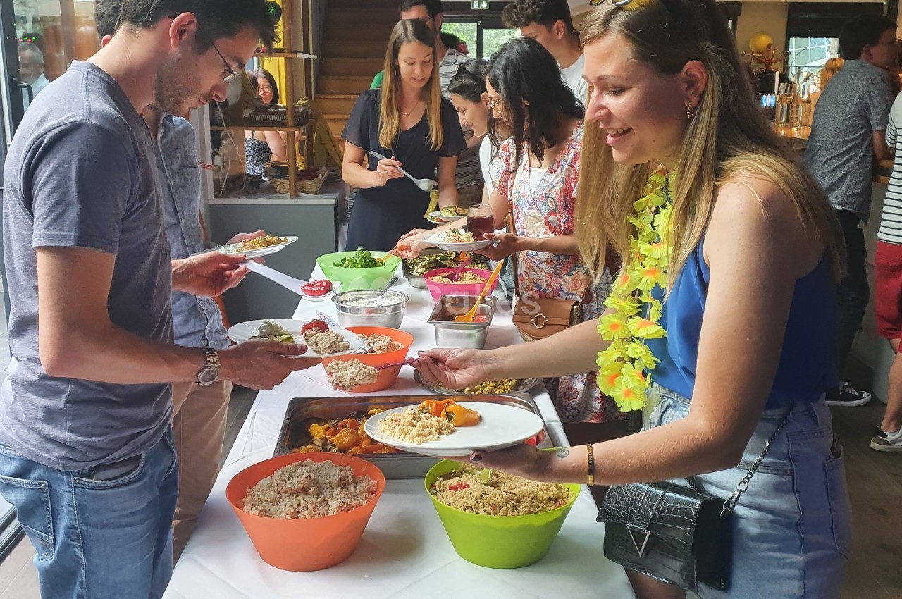 Des personnes se servent à un buffet varié dans un cadre intérieur convivial.