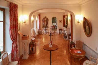 Miniature Location salle Épernay (Marne) - Château Comtesse Lafond #13 Des bouteilles de vin blanc dans une caisse en bois, avec un bar en bois et des tabourets en arrière-plan.