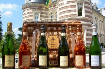 Miniature Location salle Épernay (Marne) - Château Comtesse Lafond #22 Des bouteilles de vin blanc dans une caisse en bois, avec un bar en bois et des tabourets en arrière-plan.