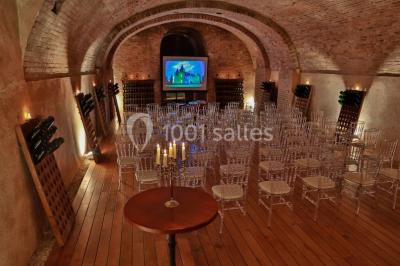 Miniature Location salle Épernay (Marne) - Château Comtesse Lafond #6 Des bouteilles de vin blanc dans une caisse en bois, avec un bar en bois et des tabourets en arrière-plan.