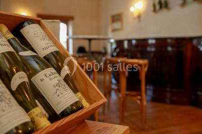 Miniature Location salle Épernay (Marne) - Château Comtesse Lafond #24 Des bouteilles de vin blanc dans une caisse en bois, avec un bar en bois et des tabourets en arrière-plan.