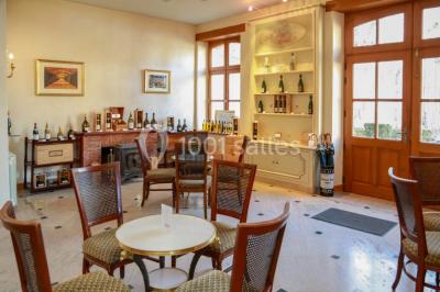 Miniature Location salle Épernay (Marne) - Château Comtesse Lafond #18 Des bouteilles de vin blanc dans une caisse en bois, avec un bar en bois et des tabourets en arrière-plan.