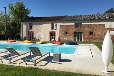 Deux lits simples avec housses rouges à pois blancs dans une chambre lumineuse décorée de touches rouges et blanches.
