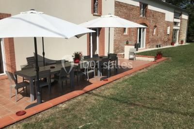 Deux lits simples avec housses rouges à pois blancs dans une chambre lumineuse décorée de touches rouges et blanches.