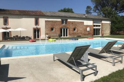 Deux lits simples avec housses rouges à pois blancs dans une chambre lumineuse décorée de touches rouges et blanches.