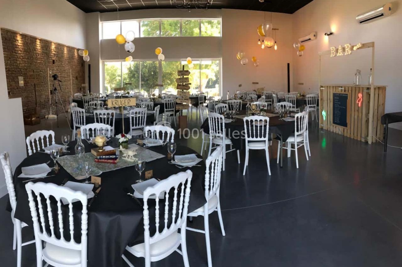 Location salle Sainte-Foy-d'Aigrefeuille (Haute-Garonne) - Les Ecuries de Ronsac #9 Salle décorée pour un événement, avec tables rondes dressées, chaises blanches et guirlandes lumineuses suspendues.