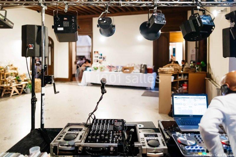 Location salle Saint-Romain-de-Colbosc (Seine-Maritime) - Château de Gromesnil #7 Matériel de DJ avec platines et ordinateur installé dans une salle, éclairée par des projecteurs suspendus.