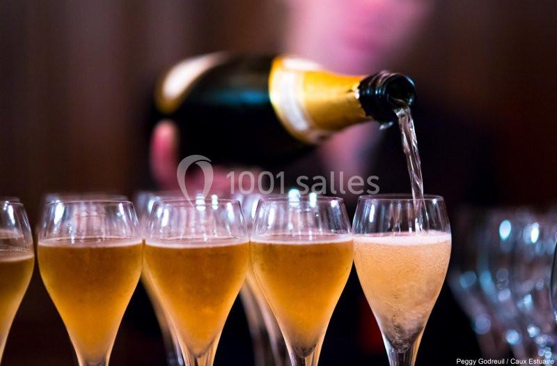 Location salle Saint-Romain-de-Colbosc (Seine-Maritime) - Château de Gromesnil #10 Un serveur verse du champagne dans plusieurs flûtes alignées sur une table.