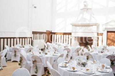 Miniature Location salle Saint-Romain-de-Colbosc (Seine-Maritime) - Château de Gromesnil #4 Pelouse verdoyante bordée d'arbres hauts sous un ciel bleu clair, avec une petite structure en briques à gauche.